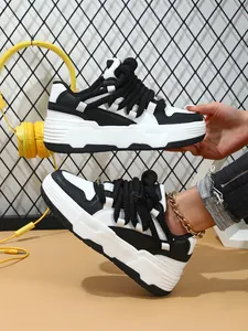 Primer plano de zapatillas de skate con plataforma en blanco y negro con cordones gruesos