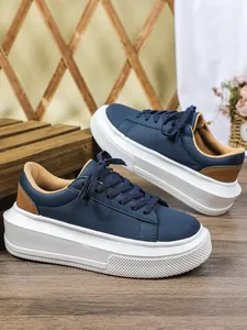 Detailweergave van stijlvolle marineblauwe damesplateausneakers met dikke witte zool.