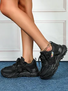 Primo piano di sneaker nere platform da donna con mesh traspirante e suole spesse
