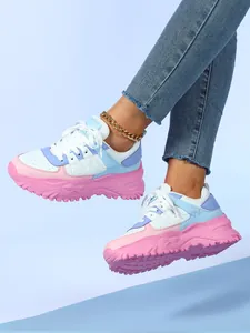 Close-up of pastel chunky sneakers with pink platform soles and blue-white mesh upper