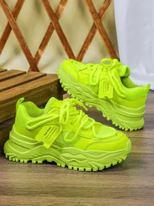 Gedetailleerd overzicht van neon groene chunky platform sneakers met ademend mesh