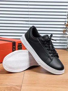 Vista dettagliata di sneaker in pelle nera con suole bianche spesse e grip testurizzato.