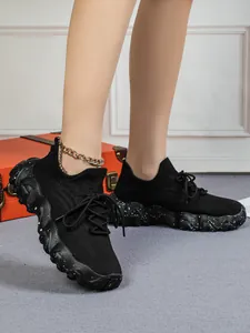 Detailansicht schwarzer Strick-Sneaker mit gesprenkelter Sohle an einem weiblichen Model