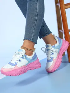Close-up of stylish pastel chunky sneakers with thick pink platform soles and white laces
