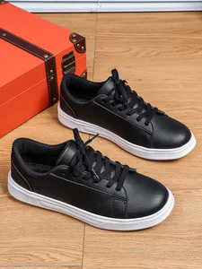 Dettaglio ravvicinato di sneaker nere casual con suole bianche spesse su legno