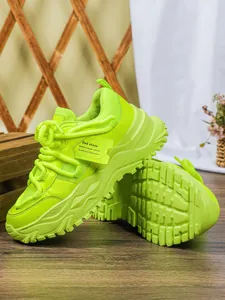 Gedetailleerd overzicht van neongroene chunky platform sneakers met ademend mesh.