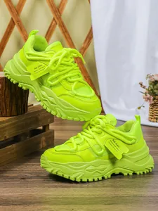 Detailweergave van neon groene chunky dad-schoenen met ademend mesh en platformzool.