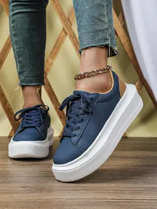 Gedetailleerd overzicht van blauwe platformsneakers met witte zool en enkelbandje