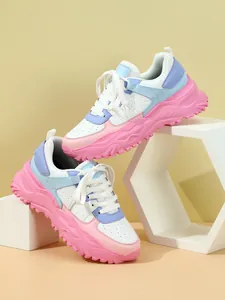 Vibrant chunky platform sneakers in pastel pink and blue colors on geometric props.