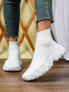 Detailopname van witte ademende fly-knit sok sneakers met dikke gespikkelde zolen