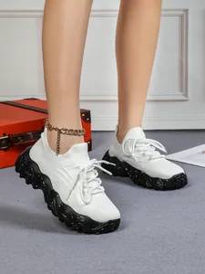 Detailaufnahme von leichten atmungsaktiven weißen Strick-Sneakern mit dicker Sohle.