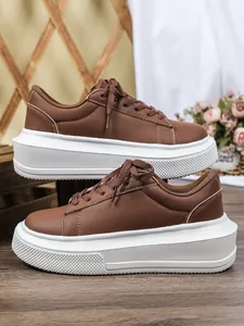 Bruine plateau sneakers voor dames met dikke witte zolen voor een stijlvolle casual look.