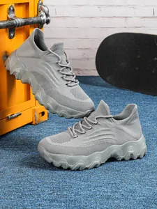 Detaillierte Seitenansicht grauer atmungsaktiver Mesh-Slipper mit dicker Wellensohle
