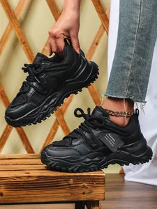 Close-up van stijlvolle zwarte platform dad-schoenen met ademend mesh en dikke zolen