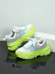 Close-up of chunky sneakers with multi-color panels and lime green platform sole