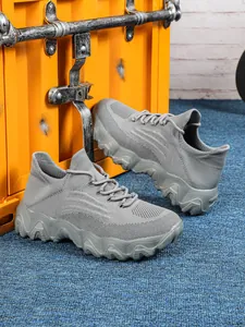 Detailansicht grauer Flyknit-Sneaker mit atmungsaktivem Mesh und welliger Plateausohle