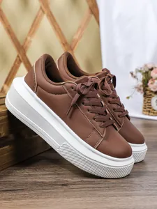 Gedetailleerd overzicht van modieuze bruine plateau sneakers met dikke witte zolen