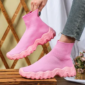 Detailopname van roze gebreide sok-sneakers met dikke golvende zolen