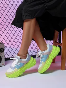 Close-up of stylish platform sneakers in multi-color pastel and neon green soles.