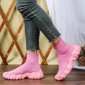 Detailweergave van roze ademende mid-top gebreide sneakers met dikke golvende zolen