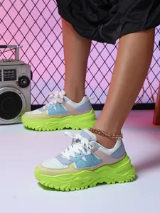 Close-up of colorful chunky sneakers with neon green soles in a street style setting