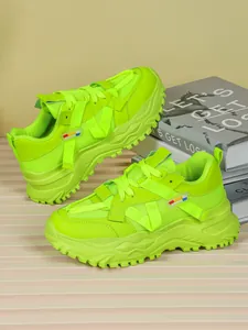 Dettaglio macro delle sneakers con zeppa verde neon con mesh e etichetta RUNNING moda.