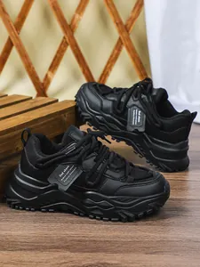 Gedetailleerd zijaanzicht van zwarte chunky platform dad schoenen met mesh panelen