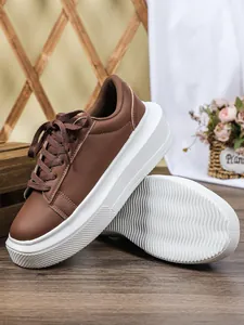 Gedetailleerd overzicht van bruine sneakers met plateauzool en dikke witte golvende zool