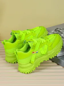 Dettaglio di sneaker chunky verde lime con mesh traspirante e suola platform spessa