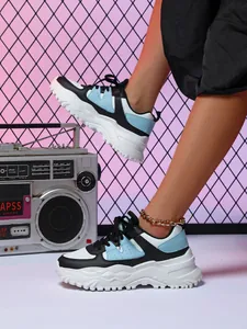 Detailed view of stylish chunky blue and black dad sneakers with a vintage radio prop