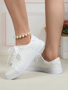 Vista ravvicinata di scarpe da ginnastica bianche casual comode indossate con cavigliera