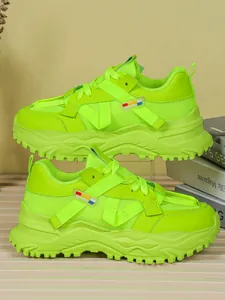 Dettaglio delle sneakers chunky verde neon con mesh traspirante e robusta suola platform.