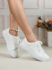 Dettaglio di scarpe da ginnastica bianche da donna con suola spessa