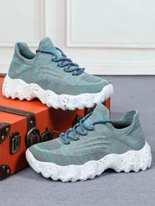 Detailansicht der atmungsaktiven blauen Fly-knit-Sneakers mit gesprenkelter Sohle.