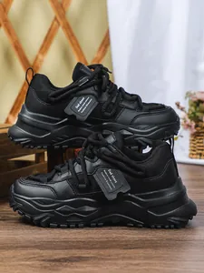 Zijprofiel detail van zwarte chunky plateau sneakers met ademende mesh textuur