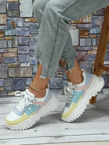 Close-up of stylish pastel color-block chunky platform sneakers on wood floor