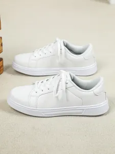 Vista laterale di sneakers bianche con plateau su sfondo di tappeto strutturato