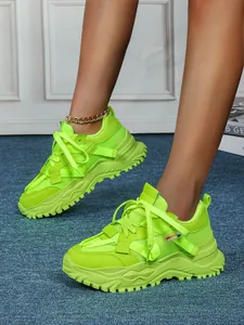 Dettaglio delle sneaker chunky verde neon con suola spessa e traspirante da donna.