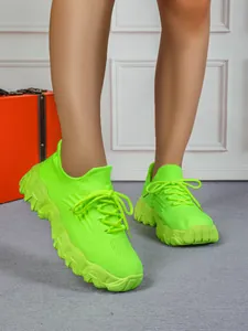Detailansicht von neongrünen Fly-Knit-Sneakern für Damen mit dicken Wellensohlen