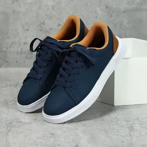Sneakers alla moda blu navy con suola spessa, dettagli marroni e suola in gomma bianca.