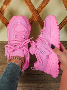 Close-up van roze chunky sneakers met plateauzool, mesh details en decoratief label.