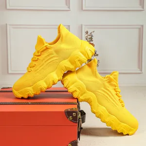 Detailansicht leuchtend gelber atmungsaktiver Strick-Sneaker auf einem Vintage-Koffer