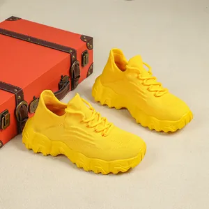 Detailansicht gelber atmungsaktiver Strick-Sneaker mit einem roten Vintage-Koffer