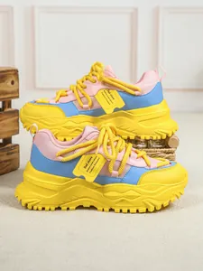 Detail van kleurrijke chunky sneakers met ademend mesh en een gele platformzool