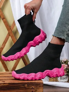 Gedetailleerde opname van de hippe zwart-roze gebreide sok-sneakers voor dames in stijl