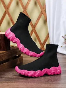 Zijaanzicht van zwarte gebreide sok-sneakers met dikke roze gegolfde zolen