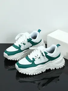 Detailed side view of white and green platform sneakers with chunky lug soles.