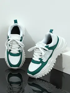Close-up of green and white chunky dad sneakers with thick platform soles and lace-up design