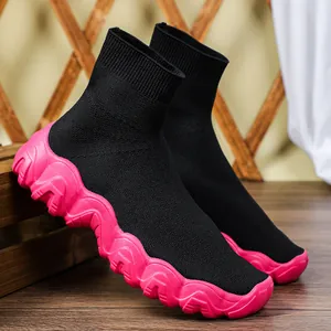 Detailweergave van zwarte gebreide sok-sneakers voor dames met dikke roze golfzool