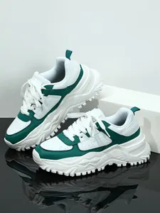 Stylish white and emerald green chunky platform sneakers on a reflective dark surface
